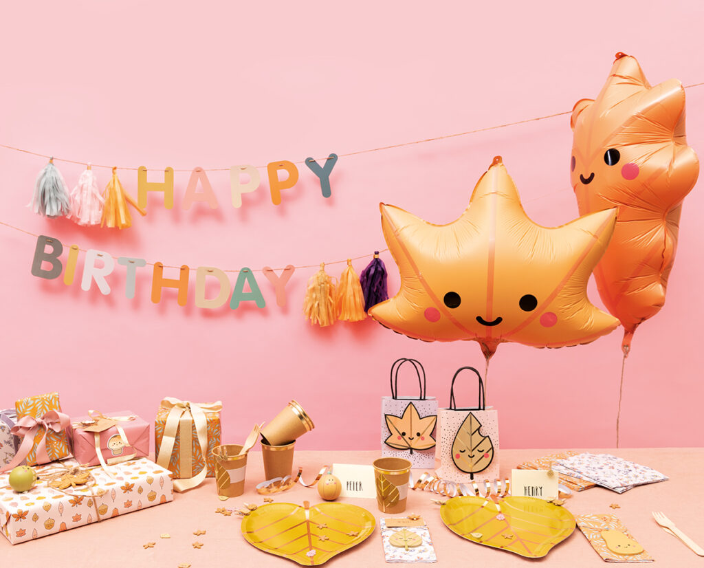 Ein gedeckter Geburtstagstisch mit Geschenken und Folienballons mit herbstlichen Motiven