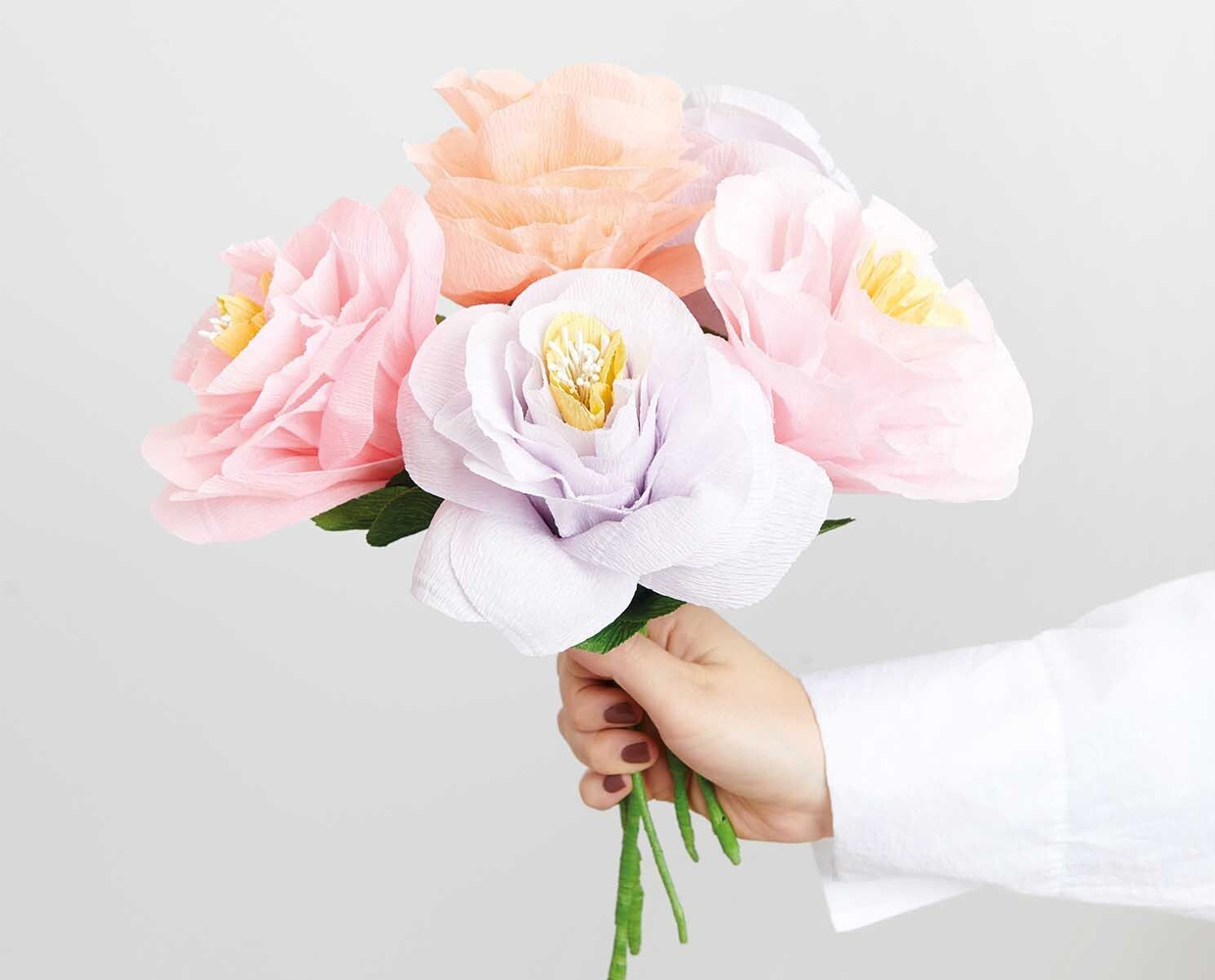 Große Blüten_ Papierblumenstrauß in der Hand